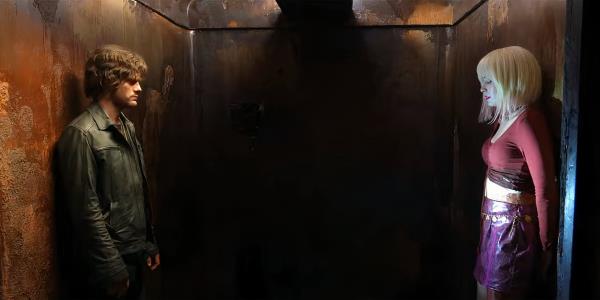 Jeremy Irvine as James Sunderland looking upset at Maria in an elevator in Return to Silent Hill