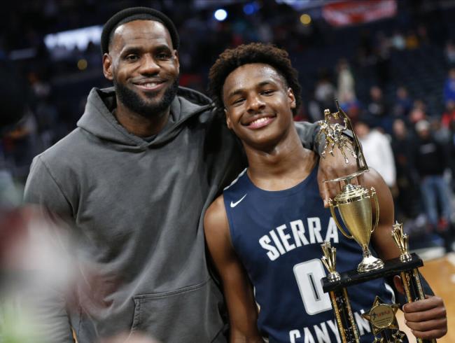 FILE - LeBron James, left, poses with his son Bro<em></em>nny after Sierra Canyon beat Akron St. Vincent - St. Mary in a high school basketball game, Saturday, Dec. 14, 2019, in Columbus, Ohio. Bro<em></em>nny James, son of NBA superstar LeBron James, was hospitalized after going into cardiac arrest while participating in a practice at Southern California on Monday, July 24, 2023. (AP Photo/Jay LaPrete, File)