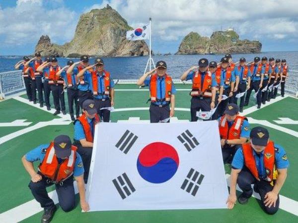 This file photo, provided by the Do<em></em>nghae Coast Guard on Aug. 14, 2023, shows its crew members saluting, with a South Korean natio<em></em>nal flag spread in front, during a ceremony marking the 78th anniversary of South Korea's liberation from Japan's colo<em></em>nial rule, held in waters near South Korea's easternmost islets of Dokdo two days earlier. (PHOTO NOT FOR SALE) (Yonhap) 