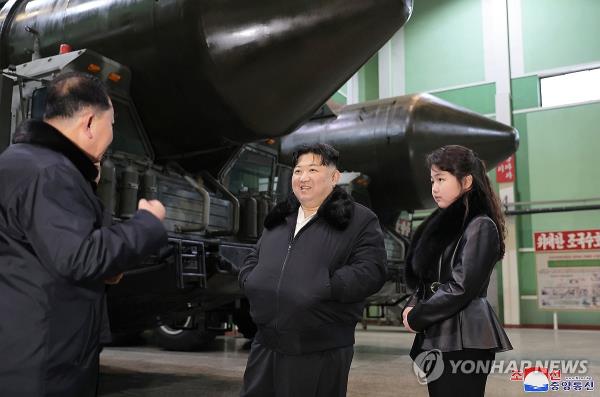 This photo, carried by North Korea's official Korean Central News Agency on Jan. 5, 2024, shows the North's leader Kim Jong-un (C) and his daughter Ju-ae (R), inspecting a factory producing transporter erector launchers for strategic missiles. (For Use o<em></em>nly in the Republic of Korea. No Redistribution) (Yonhap)
