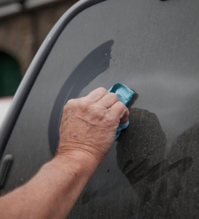 A hand wiping soot from the back of his truck.